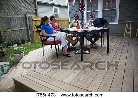 Two young couples on backyard patio on 4th of July View Large Photo Image Stock Image - Two young couples on backyard patio on 4th of July. Fotosearch