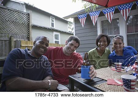 Two young couples on backyard patio on 4th of July View Large Photo Image Stock Image - Two young couples on backyard patio on 4th of July. Fotosearch