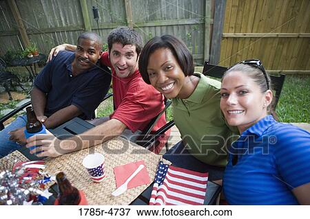 Two young couples on backyard patio on 4th of July View Large Photo Image Stock Photo - Two young couples on backyard patio on 4th of July. Fotosearch