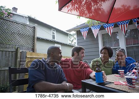 Two young couples on backyard patio on 4th of July View Large Photo Image Stock Photography - Two young couples on backyard patio on 4th of July. Fotosearch