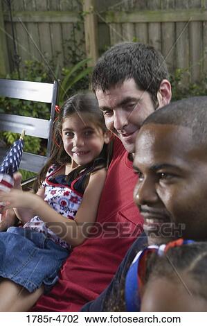 Two young girls with dads at 4th of July cookout View Large Photo Image Stock Image - Two young girls with dads at 4th of July cookout. Fotosearch