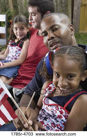 Two young girls with dads at 4th of July cookout View Large Photo Image Stock Image - Two young girls with dads at 4th of July cookout. Fotosearch