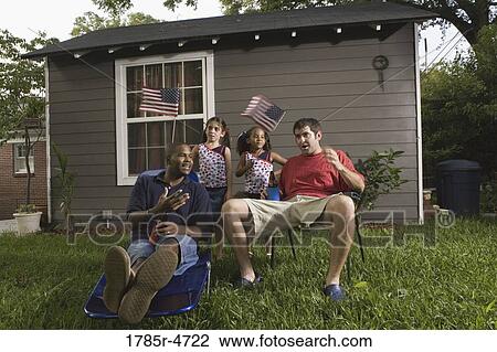 Two young men sitting on lawn chairs enjoying a beer while daughters play View Large Photo Image Stock Image - Two young men sitting on lawn chairs enjoying a beer while daughters play. Fotosearch
