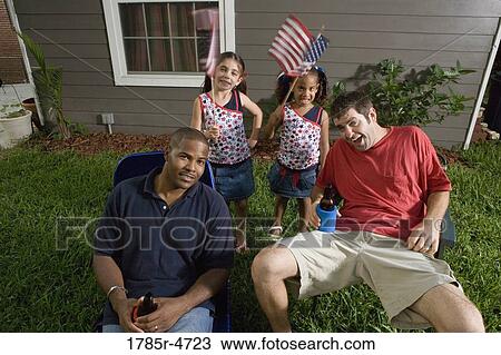 Two young men sitting on lawn chairs enjoying a beer while daughters play View Large Photo Image Stock Image - Two young men sitting on lawn chairs enjoying a beer while daughters play. Fotosearch