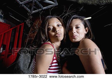 Two young women looking at camera with puckered lips View Large Photo Image Stock Image - Two young women looking at camera with puckered lips. Fotosearch