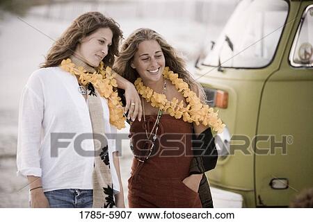 Two young women standing next to van View Large Photo Image Stock Photo - Two young women standing next to van. Fotosearch