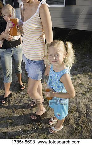 Two young women with children standing outside trailer home View Large Photo Image Stock Photo - Two young women with children standing outside trailer home. Fotosearch