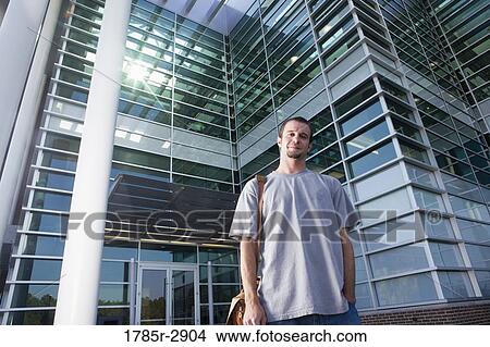 University student standing outside campus building View Large Photo Image Picture - University student standing outside campus building. Fotosearch
