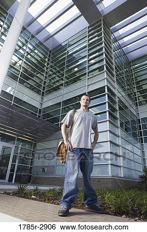 University student standing outside campus building View Large Photo Image Stock Photograph - University student standing outside campus building. Fotosearch