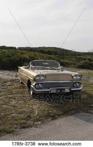 Stock Photo - View of a antique convertible car parked on grass. Fotosearch