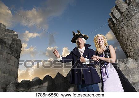 View of a navy officer and a princess with castle turrets and parapets in the background View Large Photo Image Stock Image - View of a navy officer and a princess with castle turrets and parapets in the background. Fotosearch