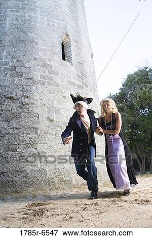 View of a navy officer and a princess sneaking around a castle wall View Large Photo Image Stock Photo - View of a navy officer and a princess sneaking around a castle wall. Fotosearch