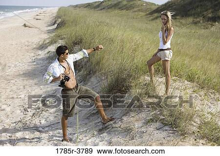 View of a young couple at the beach View Large Photo Image Stock Photo - View of a young couple at the beach. Fotosearch
