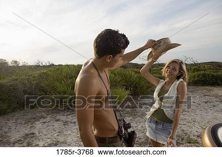 View of a young couple playfully putting hat on View Large Photo Image Stock Photo - View of a young couple playfully putting hat on. Fotosearch