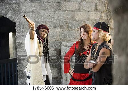 View of armed pirates against a castle wall, pointing a gun at a distant target View Large Photo Image Stock Photograph - View of armed pirates against a castle wall, pointing a gun at a distant target. Fotosearch