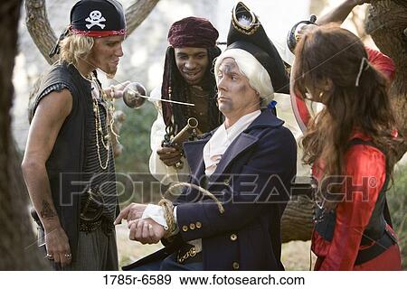 View of armed pirates holding a navy officer captive and threatening him with a sword and a gun View Large Photo Image Stock Photo - View of armed pirates holding a navy officer captive and threatening him with a sword and a gun. Fotosearch