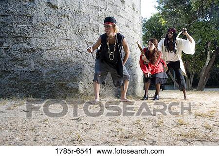 Stock Image - View of armed pirates sneaking around a castle wall. Fotosearch