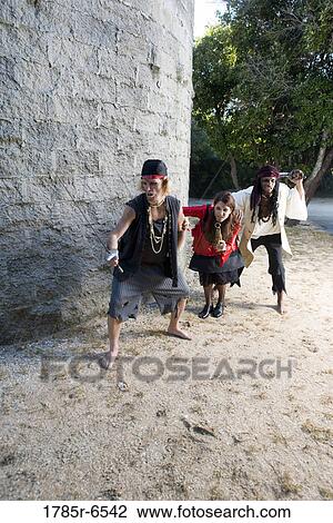 Stock Image - View of armed pirates sneaking around a castle wall. Fotosearch