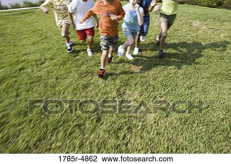 Stock Image - View of children's feet running towards the viewer. Fotosearch
