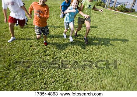 Stock Image - View of children's feet running towards the viewer. Fotosearch