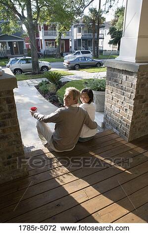 View of interracial couple sitting on front steps of house View Large Photo Image Stock Image - View of interracial couple sitting on front steps of house. Fotosearch