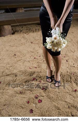 View of lower half of a woman in black holding a bouquet of white roses View Large Photo Image Stock Photograph - View of lower half of a woman in black holding a bouquet of white roses. Fotosearch
