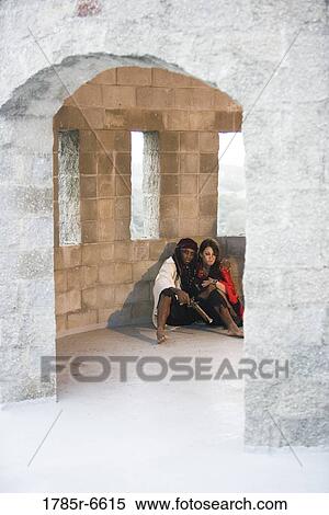 View of pirates armed with a gun hiding against a castle wall View Large Photo Image Stock Photography - View of pirates armed with a gun hiding against a castle wall. Fotosearch