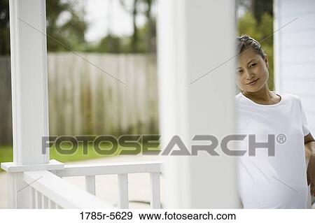 View of pregnant woman standing on porch View Large Photo Image Stock Photo - View of pregnant woman standing on porch. Fotosearch