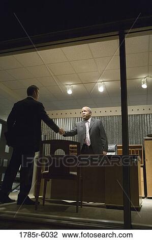 View through window of businessmen in office shaking hands View Large Photo Image Stock Image - View through window of businessmen in office shaking hands. Fotosearch