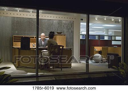 View through window of man and woman talking in an office View Large Photo Image Stock Photo - View through window of man and woman talking in an office. Fotosearch