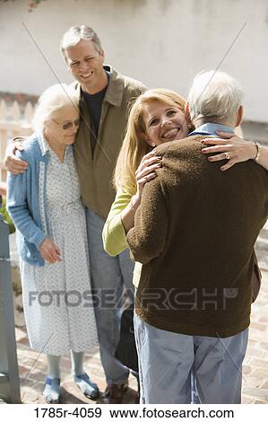 Woman hugging senior man while man and senior woman watch View Large Photo Image Stock Photo - Woman hugging senior man while man and senior woman watch. Fotosearch