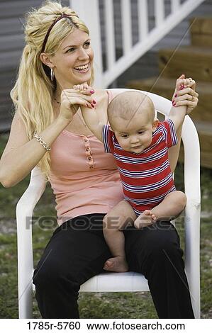 Woman playing with her baby on her lap View Large Photo Image Stock Image - Woman playing with her baby on her lap. Fotosearch