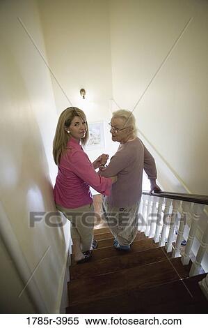 Woman supporting and helping senior woman down the stairs View Large Photo Image Stock Photography - Woman supporting and helping senior woman down the stairs. Fotosearch