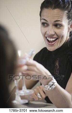 Stock Image - Woman toasting with a cocktail. Fotosearch