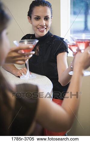 Woman toasting with a cocktail View Large Photo Image Stock Photography - Woman toasting with a cocktail. Fotosearch
