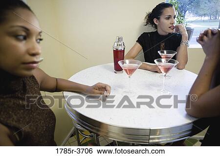 Women sitting with drinks on table View Large Photo Image Stock Photograph - Women sitting with drinks on table. Fotosearch