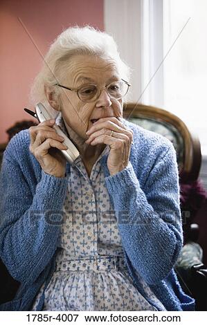 Worried and pensive senior woman talking on cordless phone View Large Photo Image Stock Photo - Worried and pensive senior woman talking on cordless phone. Fotosearch