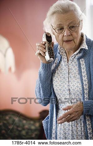 Worried senior woman talking on cordless phone View Large Photo Image Picture - Worried senior woman talking on cordless phone. Fotosearch