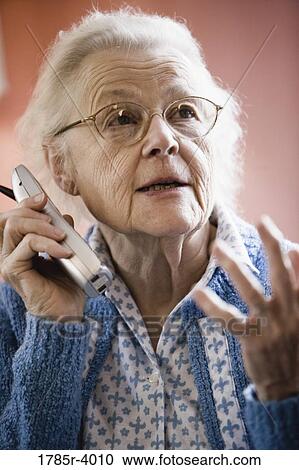 Worried senior woman talking on cordless phone View Large Photo Image Stock Image - Worried senior woman talking on cordless phone. Fotosearch