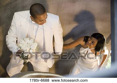 Young bride and groom ascending spiral staircase View Large Photo Image Stock Photo - Young bride and groom ascending spiral staircase. Fotosearch