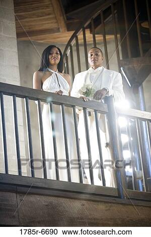 Young bride and groom looking down over balcony railing View Large Photo Image Stock Image - Young bride and groom looking down over balcony railing. Fotosearch