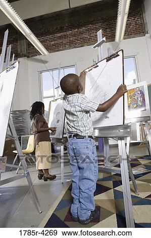 Young children drawing on easels in art class View Large Photo Image Stock Photo - Young children drawing on easels in art class. Fotosearch