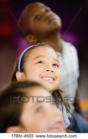 Young children watching and listening attentively View Large Photo Image Stock Image - Young children watching and listening attentively. Fotosearch