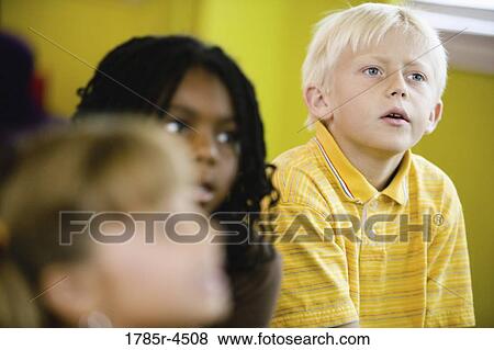 Young children watching and listening attentively View Large Photo Image Stock Photo - Young children watching and listening attentively. Fotosearch