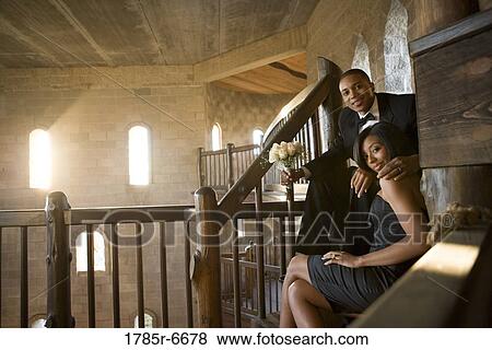 Young couple in formal attire sitting on stairs inside medieval castle View Large Photo Image Stock Photo - Young couple in formal attire sitting on stairs inside medieval castle. Fotosearch
