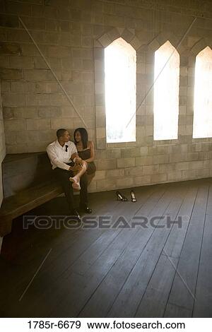 Stock Photo - Young couple in formal attire sitting next to windows in medieval castle. Fotosearch