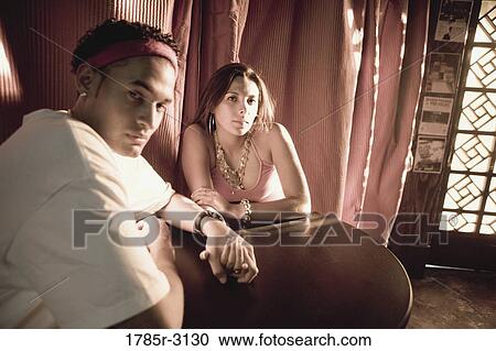 Young couple in hip-hop fashion sitting at a table View Large Photo Image Stock Image - Young couple in hip-hop fashion sitting at a table. Fotosearch