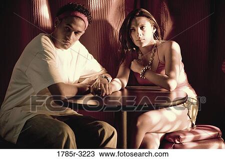 Young couple in hip-hop fashion sitting at a table View Large Photo Image Stock Image - Young couple in hip-hop fashion sitting at a table. Fotosearch