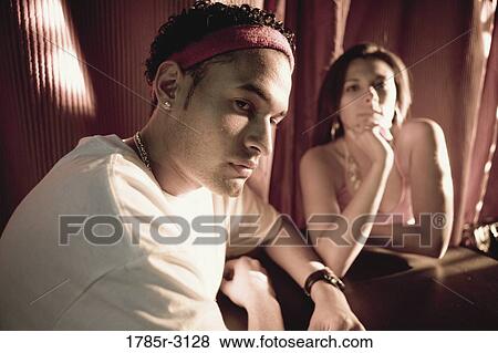 Young couple in hip-hop fashion sitting at a table View Large Photo Image Stock Photo - Young couple in hip-hop fashion sitting at a table. Fotosearch