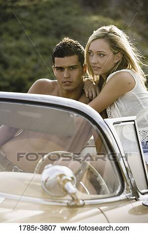 Young couple sitting in antique convertible car View Large Photo Image Stock Photo - Young couple sitting in antique convertible car. Fotosearch